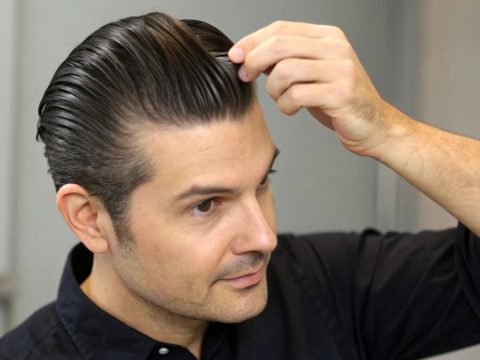 Man with thinning hair styled in a sleek slick-back hairstyle, demonstrating hair styling tips and techniques for men.