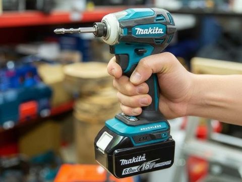 Makita XDT19Z 18V compact impact driver held in hand showing ergonomic grip and 1 by 4-inch hex chuck