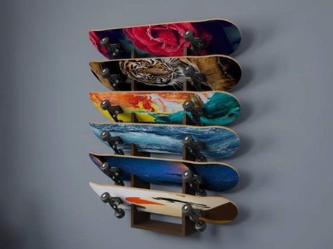 A sleek 5-layer skateboard wall rack mounted on a bedroom wall, holding five colorful decks vertically with graphics on display