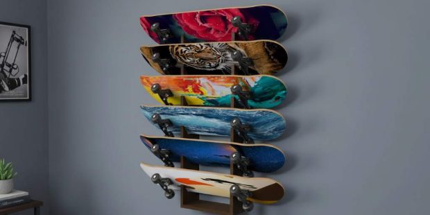 A sleek 5-layer skateboard wall rack mounted on a bedroom wall, holding five colorful decks vertically with graphics on display