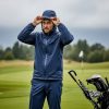 golfer preparing waterproof golf gear in rainy conditions