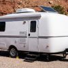 Camper parked under desert cliffs in Moab during summer heat