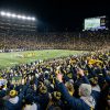 Packed college football stadium crowd cheering during a 2026–27 College Football Playoff first-round game played at a campus home site in December 2026