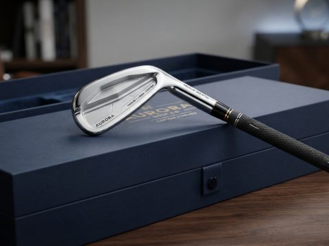 Polished custom iron golf club resting on a luxury gift box.