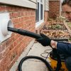 Person connecting a flexible vacuum hose to an outdoor dryer vent.