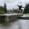 Skateboarder landing a big drop with bent knees in Portland