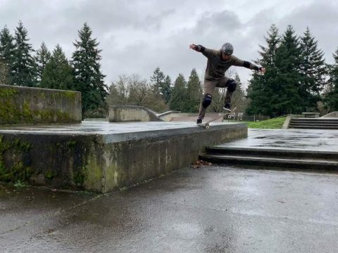 Skateboarder landing a big drop with bent knees in Portland