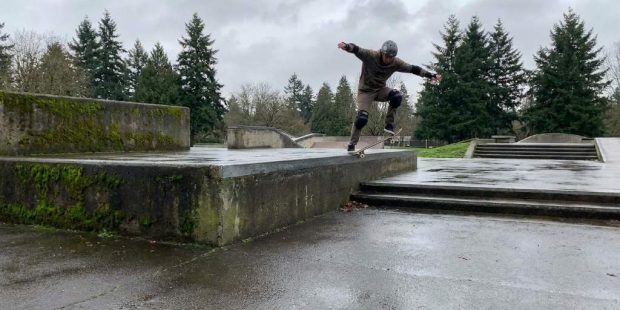 Skateboarder landing a big drop with bent knees in Portland