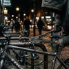 A thief cutting a thin cable lock on a bicycle.
