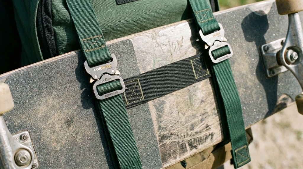 Close-up of durable backpack straps securely holding a skateboard.