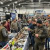 Anglers browsing ice fishing rods and reels at a crowded winter show